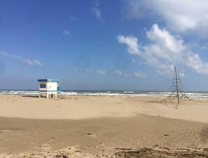 Una spiaggia con una torretta di salvataggio e una struttura metallica.