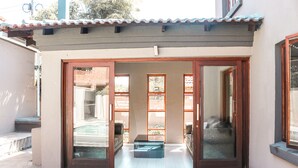 Un pequeño patio amurallado con puerta corrediza de vidrio que da a un balcón.