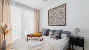 Un dormitorio ordenado con cama, mesita de noche y un adorno en la pared.