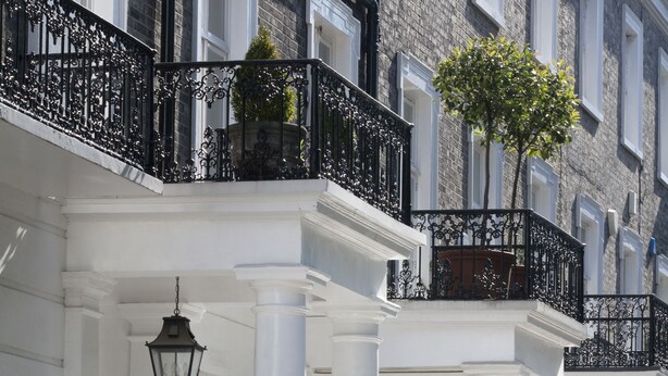 A row of numbered white buildings with black iron railings and columns. - Avari Apartments - Winchester Collection (London)