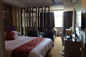 Une chambre d’hôtel comprenant un lit, un bureau avec un ordinateur, une chaise et un téléviseur.