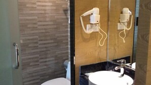Een badkamer met een toilet, wastafel en spiegel.