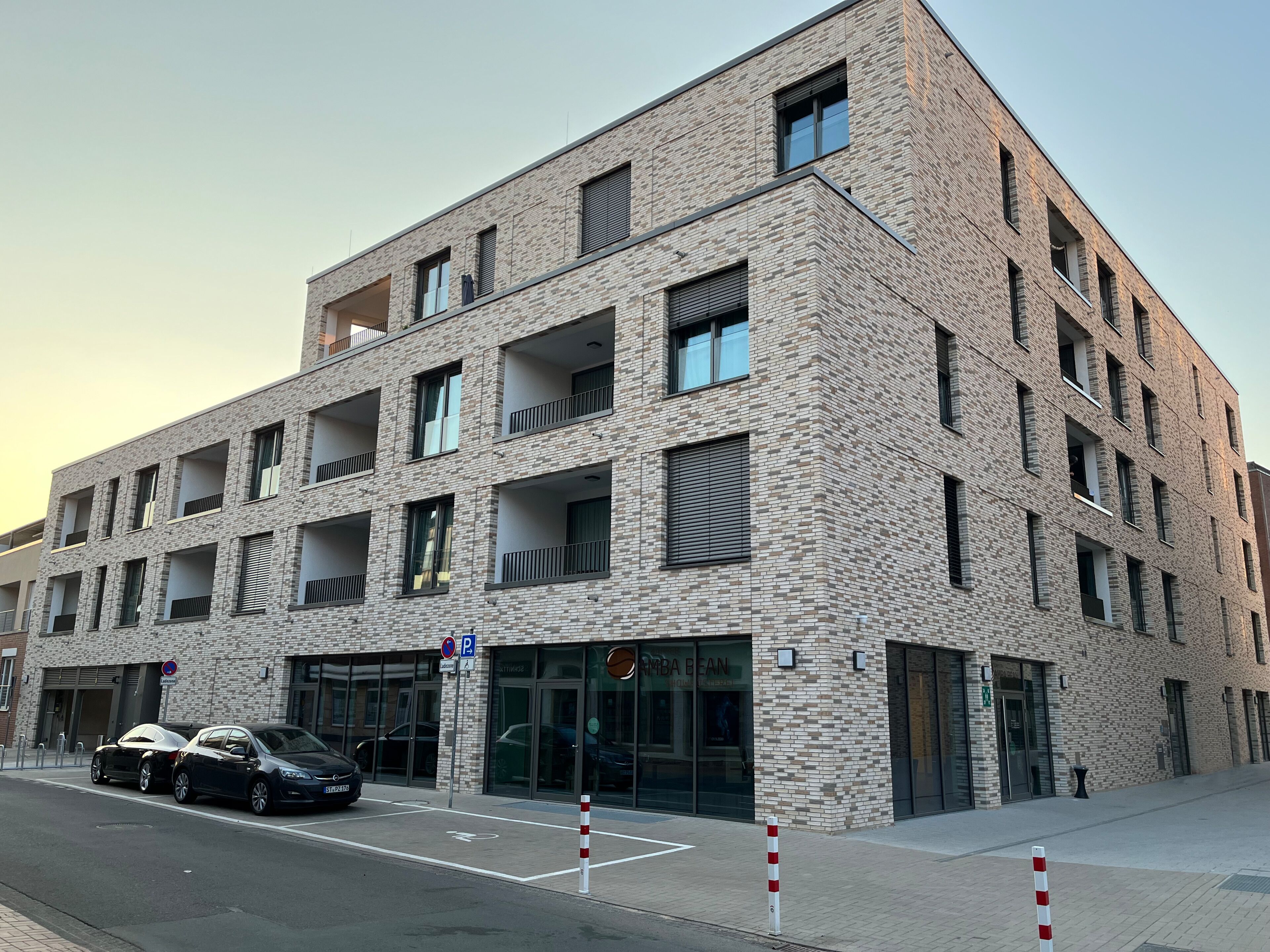 A multi-story building with a brick facade, large windows, and balconies.