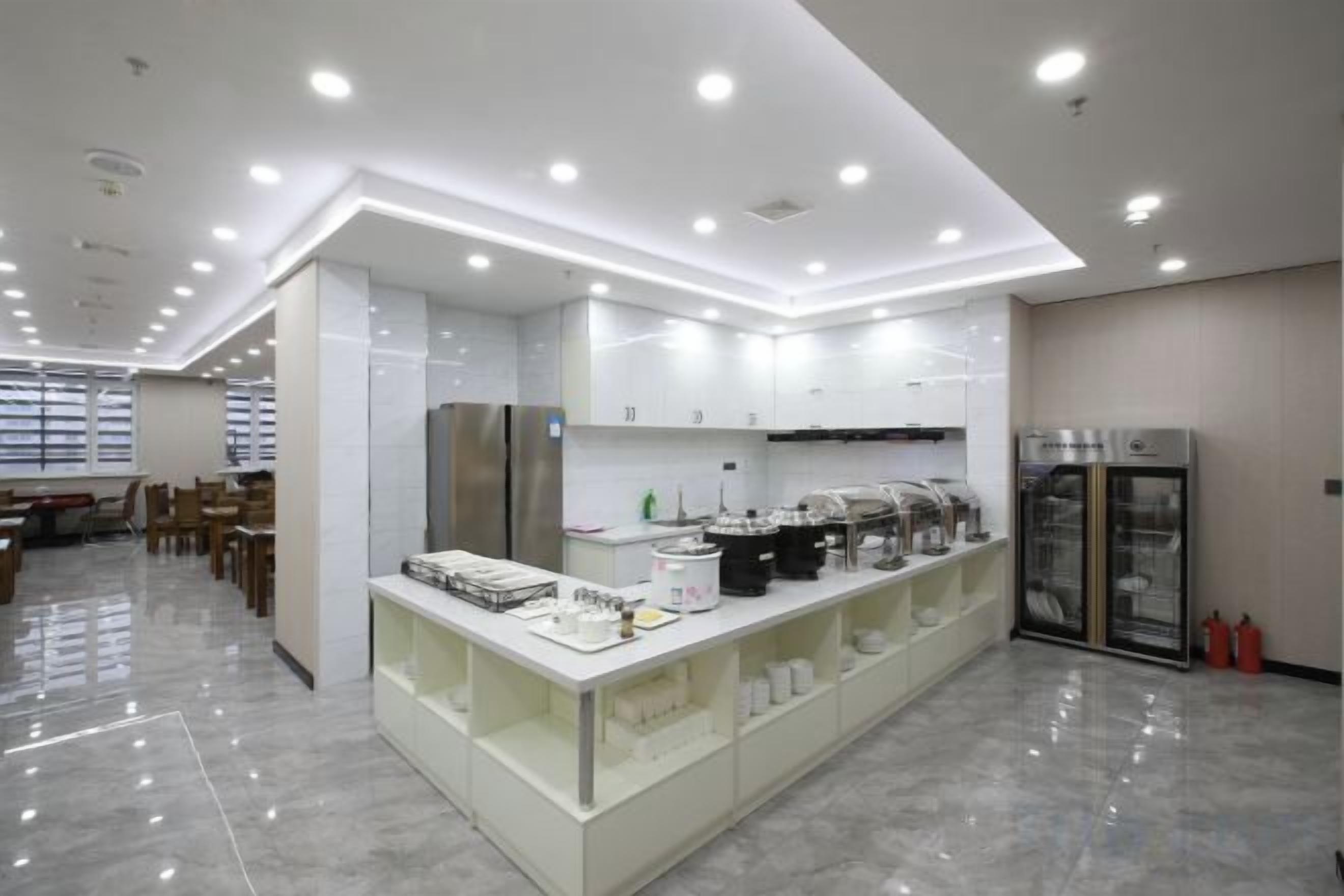 Une cuisine moderne dotée d’un îlot central, d’appareils électroménagers intégrés et d’un coin repas avec des chaises.