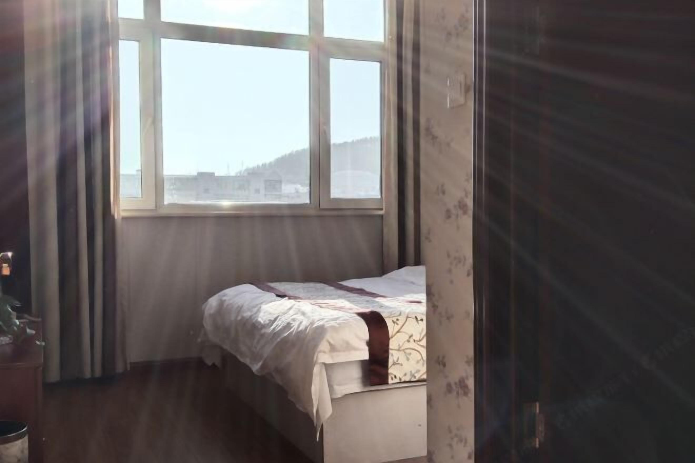 Een slaapkamer met een bed, een raam en een deur.