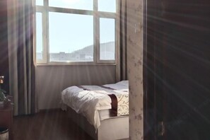 Une chambre à coucher avec un lit, une fenêtre et une porte.