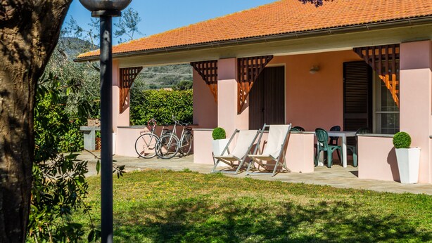 A building with a tiled roof, outdoor seating, and bicycles.