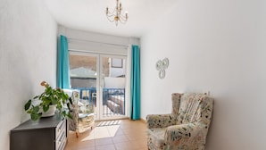 A room with a chair, a cabinet, a potted plant, a chandelier, and a view through a glass door. - Holiday Home "Adriana" with Private Pool, Terrace, and Wi-Fi (Murchas)