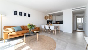 Un salon moderne avec un canapé, une table basse et un coin repas.