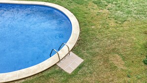 A circular pool with a tiled edge and a small tiled platform with steps leading into the water. - Apartment 'Montgo' with Mountain View, Wi-Fi and Air Conditioning (L'Escala)