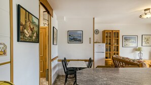 A dining area with a marble table, chairs, and a view of the kitchen. - Apartment 'Montgo' with Mountain View, Wi-Fi and Air Conditioning (L'Escala)