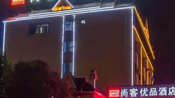 Un hotel con un letrero llamativo y líneas verticales iluminadas en la fachada.