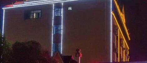 A hotel with a prominent sign and illuminated vertical lines on the facade.