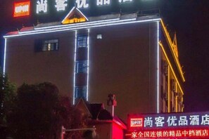 Un hôtel doté d’une enseigne bien visible et de lignes verticales illuminées sur sa façade.