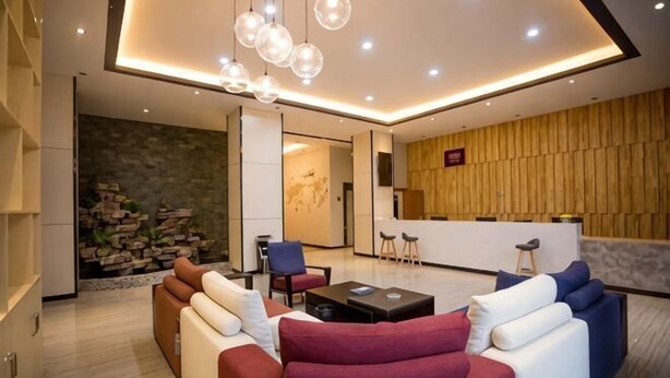Un soggiorno moderno con un divano, un tavolino da caffè e una zona pranzo con parete in legno e una reception.