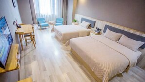 Camera d'albergo con due letti, una scrivania, una sedia e una televisione.