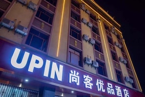 A hotel with a prominent 'UPIN' sign, indicating it is a premium establishment.