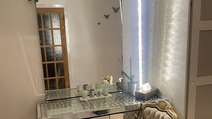 A room with a glass desk, a chair, a mirror, and a door. - Impeccable 3- Bedroom House in Kirkcaldy (Kirkcaldy)