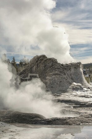 Un geyser dont la vapeur jaillit d’une formation rocheuse.