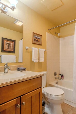 A bathroom with a sink, toilet, and shower area. - Lodgepole Condo Unit 5 (West Yellowstone)