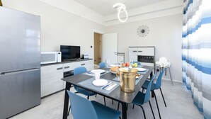 Eine moderne Küche mit Essbereich, Edelstahlgeräten und blauen Stühlen.