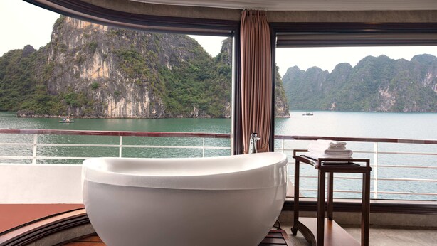 A large bathtub in a room with a view of a mountainous coastline. - Aqua Of The Seas Cruise Ha Long (Tuan Chau)