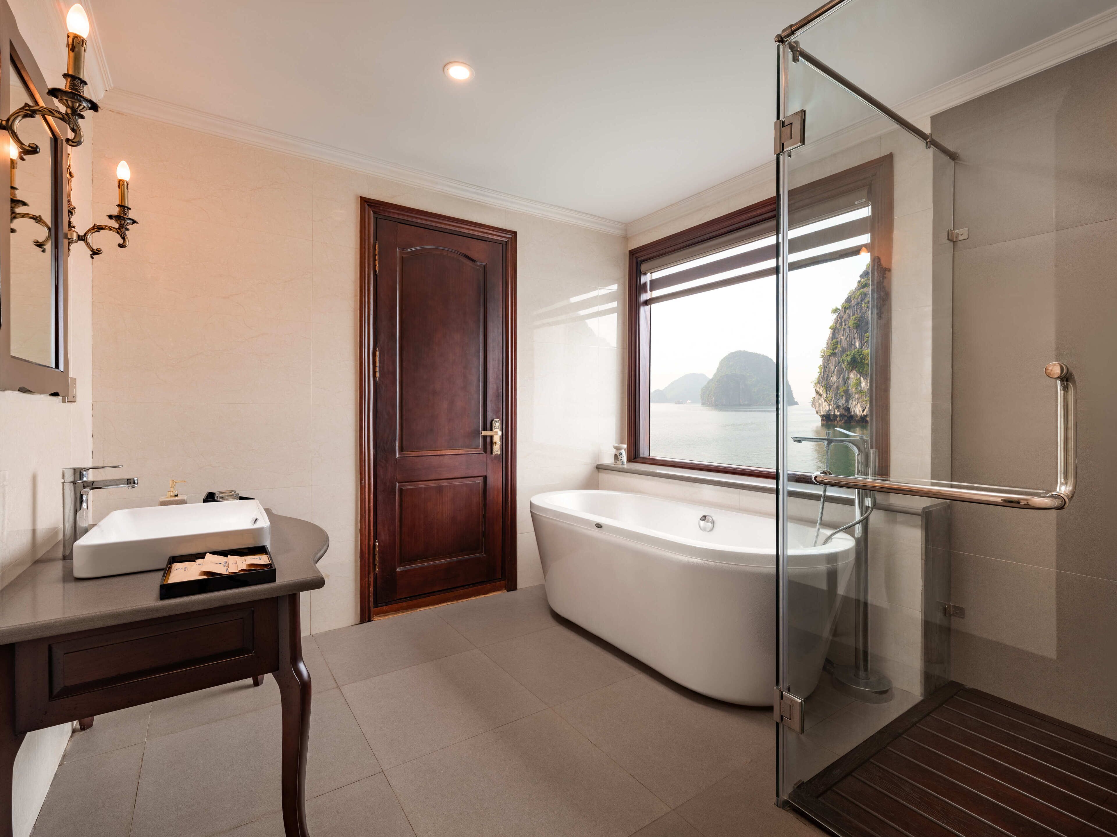 Een moderne badkamer met een vrijstaand bad, een douchecabine met glazen wanden en een wastafelmeubel met een wastafel.