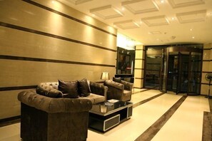 A modern lobby with a sofa, armchairs, and a coffee table.