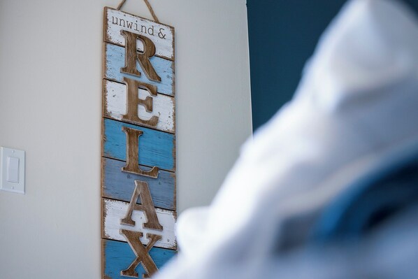 A wall-mounted sign with the words "unwind & RELAX" in a rustic style. - Beach1 Waterfront Stunning Views (Wasaga Beach)