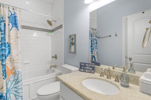 Un baño con bañera, inodoro y lavamanos.