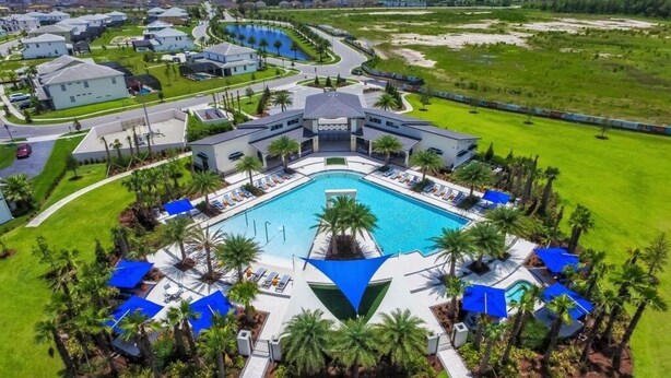 A large resort with a central swimming pool surrounded by lounge areas and palm trees. - The Ultimate New 15 Bedroom Vernada Villa by RedAwning (Kissimmee)
