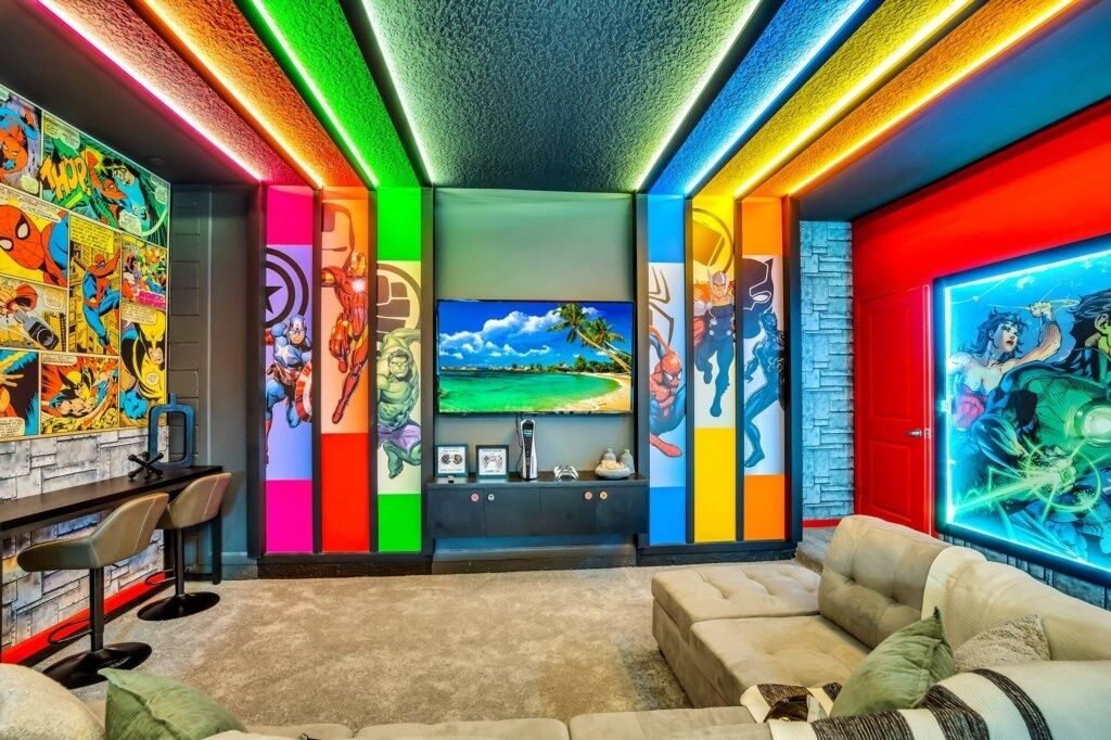 Ein lebendiger Raum mit einem großen Fernseher, farbenfrohen Wandgemälden und einer Bar.