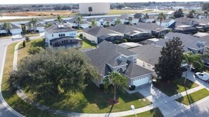 Un quartier résidentiel avec des maisons modernes, des pelouses bien entretenues et un grand bâtiment en arrière-plan.