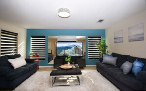 A living room with two sofas, a coffee table, a TV, and a plant.