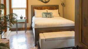 A bedroom with a bed, a bedside table, a ceiling fan, a window, and a door. - An Oasis indeed in Amish Country (Millersburg)