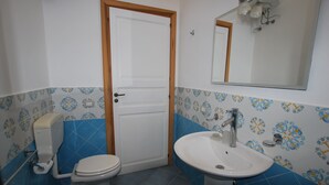 A bathroom with a toilet, bidet, sink, and mirror. - Casa Al Mar Canneto Via Mazzini (Lipari)