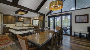 Una cocina amplia con una isla grande, taburetes de madera y una mesa de comedor.