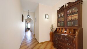 A hallway with a wooden cabinet, a vase with plants, and a tiled floor. - Apartment 'Lagos Terrace Villa' with Private Terrace, Wi-Fi and Air Conditioning (Lagos)