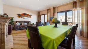 A dining area with a table set for four, a sofa, and a decorative wall piece. - Apartment 'Lagos Terrace Villa' with Private Terrace, Wi-Fi and Air Conditioning (Lagos)