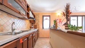 A kitchen with wooden cabinets, a stainless steel sink, and a decorative vase on the counter.