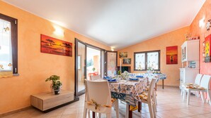 Un comedor con una mesa dispuesta para cuatro, sillas, un banco y obras de arte en las paredes.