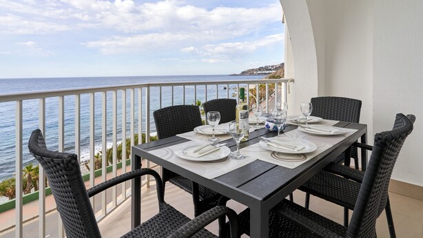 A dining table set for four with a view of the ocean. - Apartment 'With Garage In Almuñecar' with Sea View, Wi-Fi and Air Conditioning (Almunecar)