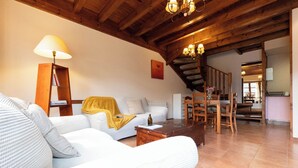 A living room with a sofa, a coffee table, a lamp, and a staircase leading to another room. - RURAL HOUSE WITH VIEWS OF THE GREEN ASTURIAN MOUNTAINS (Pola de Lena)