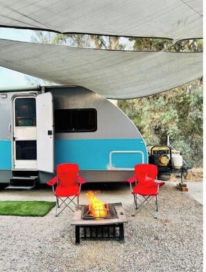 Relax in the RV's shaded seating area, complete with a fire pit for cozy gatherings.