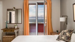 A bedroom with a bed, a dresser, a mirror, a nightstand, a lamp, and a view of mountains through a sliding door. - The Hillside Villas, Stunning Views & Private Pool (Corfu)
