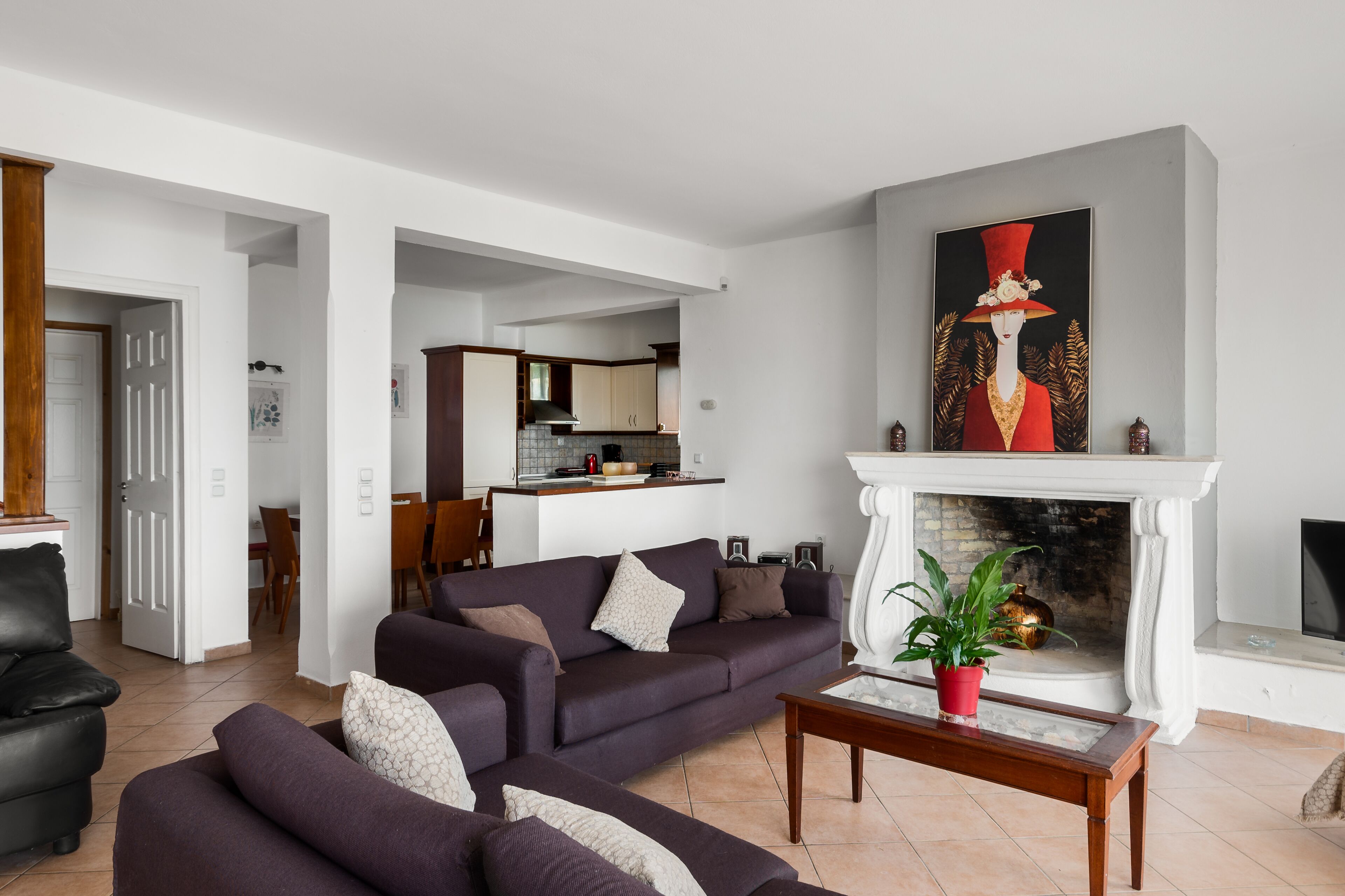 Una sala de estar con un sofá, una chimenea y un cuadro.