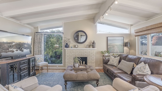 A spacious living room with a fireplace, comfortable seating, and a television. - 3874 Mission Fields - Adorable Carmel Custom Home (Carmel)