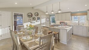 A spacious kitchen with a central island, white cabinetry, and pendant lighting. - 3874 Mission Fields - Adorable Carmel Custom Home (Carmel)