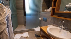 Une salle de bain équipée d’une douche, de toilettes, d’un lavabo et d’un porte-serviettes.