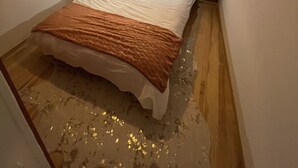 Et soveværelse med seng, et natbord, en lampe og en loftlampe.